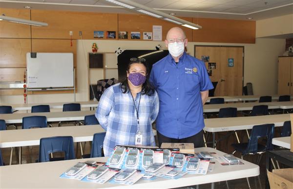 A staff member and Wilsonville Rotarian take a picture with donated calculators.
